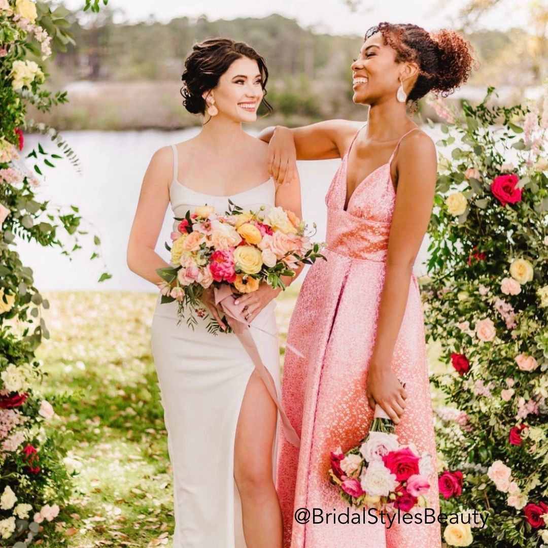 Bride and Bridesmaid surrounded by roses wearing their hair in updos wearing Easy Updo Extensions by Kristen with Bridal Styles Beauty